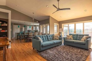 A modern living room with a sofa set, a dining area, and a kitchen in the background. - 550 Massive 4 Bedroom Home Sleeps 19 (Candler)
