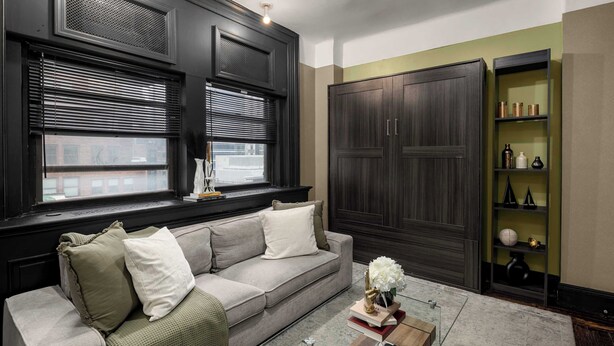A living room with a grey sofa, a glass coffee table, and a dark wooden wardrobe. - Centrally Located APT in NYC Walk to Time Square (New York)