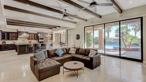 A spacious living area with a large sectional sofa, a round coffee table, and a ceiling fan. - 591d Theater Room 11 Beds - Spa (Las Vegas)