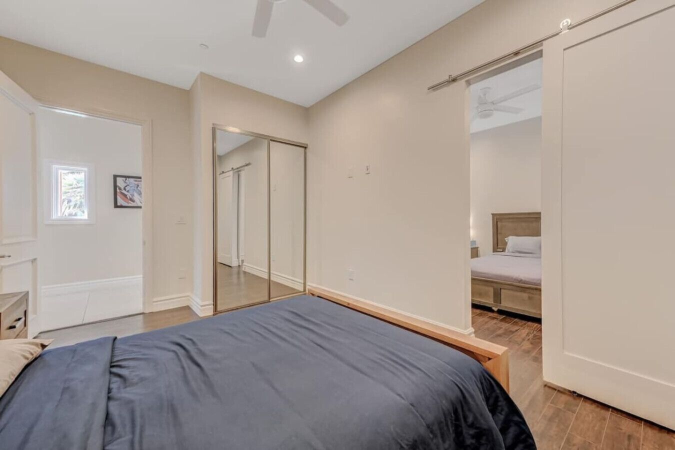 A bedroom with a bed, a wardrobe, and a mirror.
