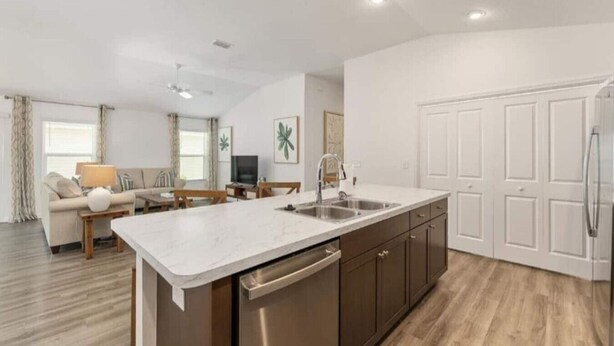A modern kitchen with a central island, built-in dishwasher, and a large white cabinet. - 561l Stunning Home, Pool Access, Garage Parking! (Okahumpka)