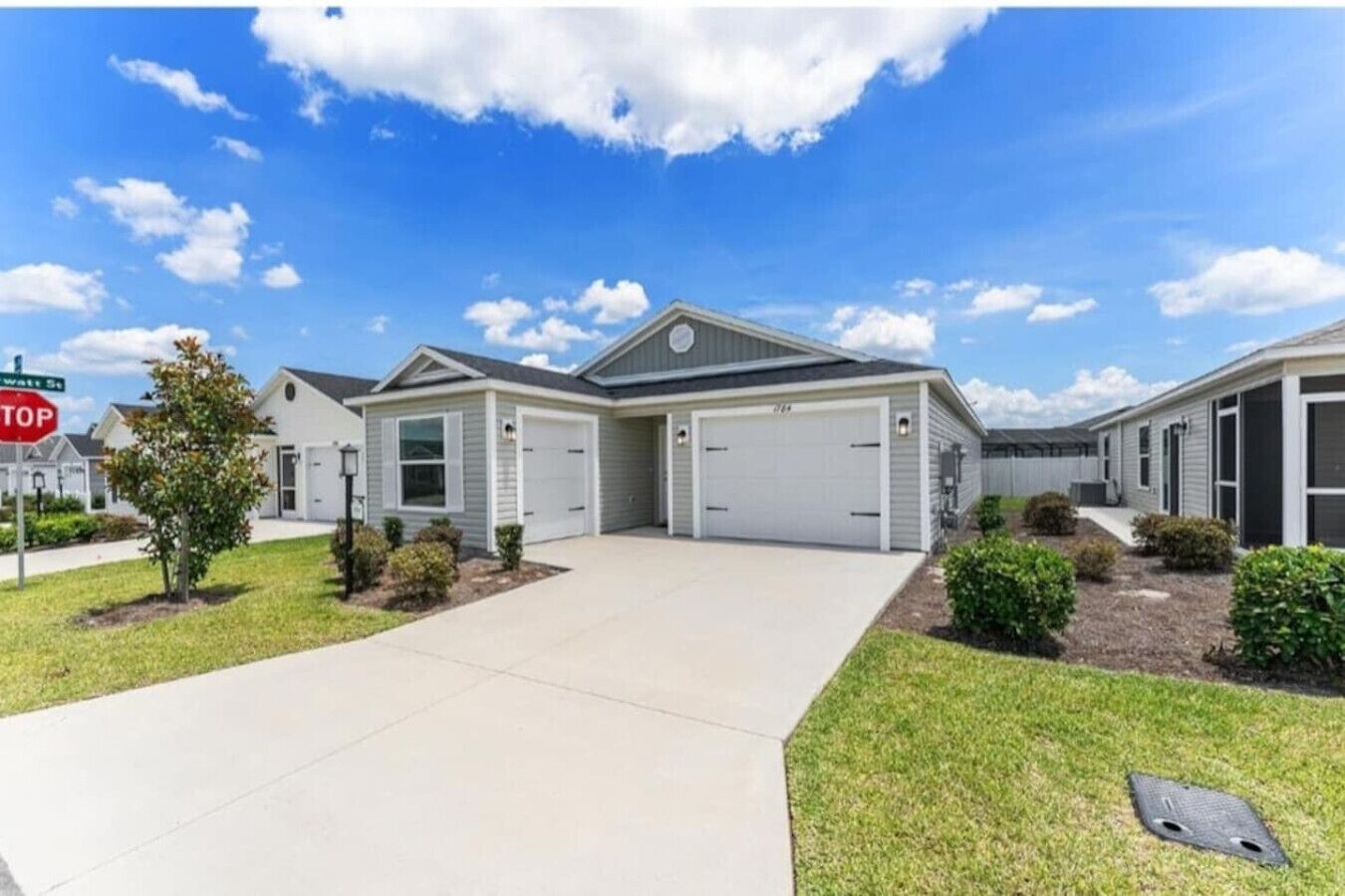 A residential building with a garage, a driveway, and a well-maintained lawn.