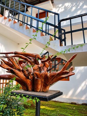 A staircase with a blue railing and a wooden sculpture resembling a tree trunk.