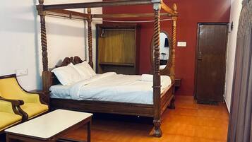 A four-poster bed with a wooden frame and a ceiling fan above.