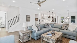 A modern living room with a sectional sofa, a coffee table, and a rustic side table. - 543 Private Pool Beach Golf Cart 12 Bedroom (Santa Rosa Beach)