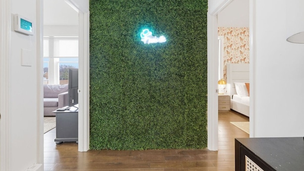 A room with a green wall, a bed, and a lamp. - Apex Executive Apartments - 30th Ave (Nashville)