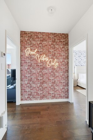 A room with a brick wall and a neon sign that reads "Good Vibes Only." - Central 3BR Apt Minutes to Downtown Parking (Nashville)