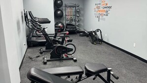 A gym with treadmills, a bench press, and weightlifting equipment.