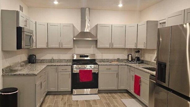 A modern kitchen with stainless steel appliances, light grey cabinets, and a herringbone patterned floor. - 632 4 Large Bedrooms Spacious Private Yard (Dallas)