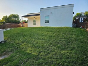 Una casa moderna con techo plano, un porche cubierto y un césped cuidado.