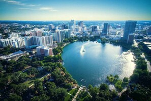 An aerial view of a city with a large body of water, surrounded by high-rise buildings and greenery. - 561j Large 2 Bedroom With King bed and Patio! (Orlando)