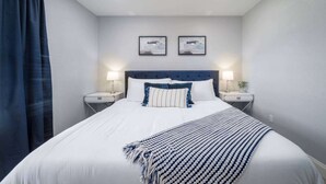 A hotel room with a large bed, two bedside tables, a headboard, and two framed pictures on the wall. - 561j Large 2 Bedroom With King bed and Patio! (Orlando)