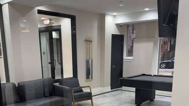A modern living room with a pool table, a sofa, and a chair. - 610e Very Comfortable Studio Downtown (Albany)