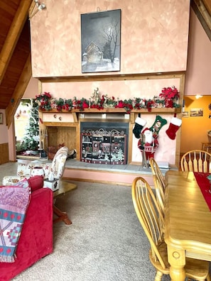 A cozy living room with a fireplace, a dining table, and a Christmas tree. - 653 4 Bedrooms Fireplace Pool Table Peaceful (Champion)