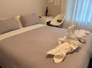 A hotel room with a bed, a desk, a chair, and a window with curtains. - Escape Heaven! Tranquility Guaranteed, Fully Fenced Pet Friendly (Palm Coast)