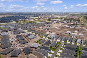 A residential area with multiple houses, roads, and a river in the background. - 561i Golf Cart Pool Access Garage Parking (Wildwood)