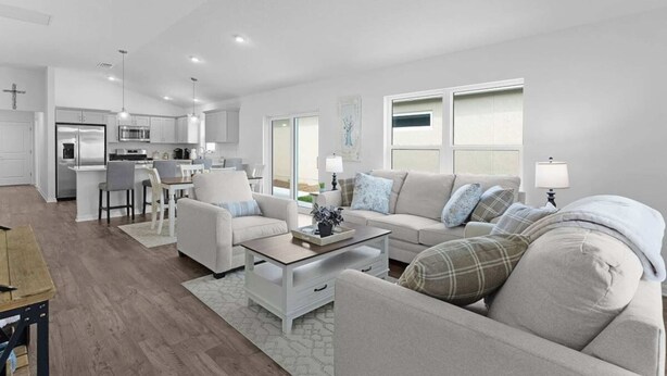 A modern living room with a sofa, coffee table, and dining area. - 561i Golf Cart Pool Access Garage Parking (Wildwood)