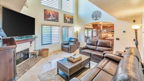 A spacious living room with a fireplace, leather sofas, and a television. - 647 5 Bedrooms Hot Tub Firepit BBQ Kitchen (Glendale)