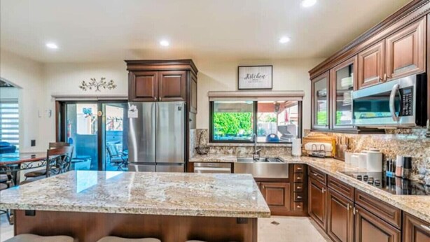 A kitchen with granite countertops, stainless steel appliances, and wooden cabinets. - 647 5 Bedrooms Hot Tub Firepit BBQ Kitchen (Glendale)