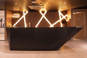 Ein Empfangsschalter mit modernem Design, der geometrische Lichtmuster und ein Logo zeigt.