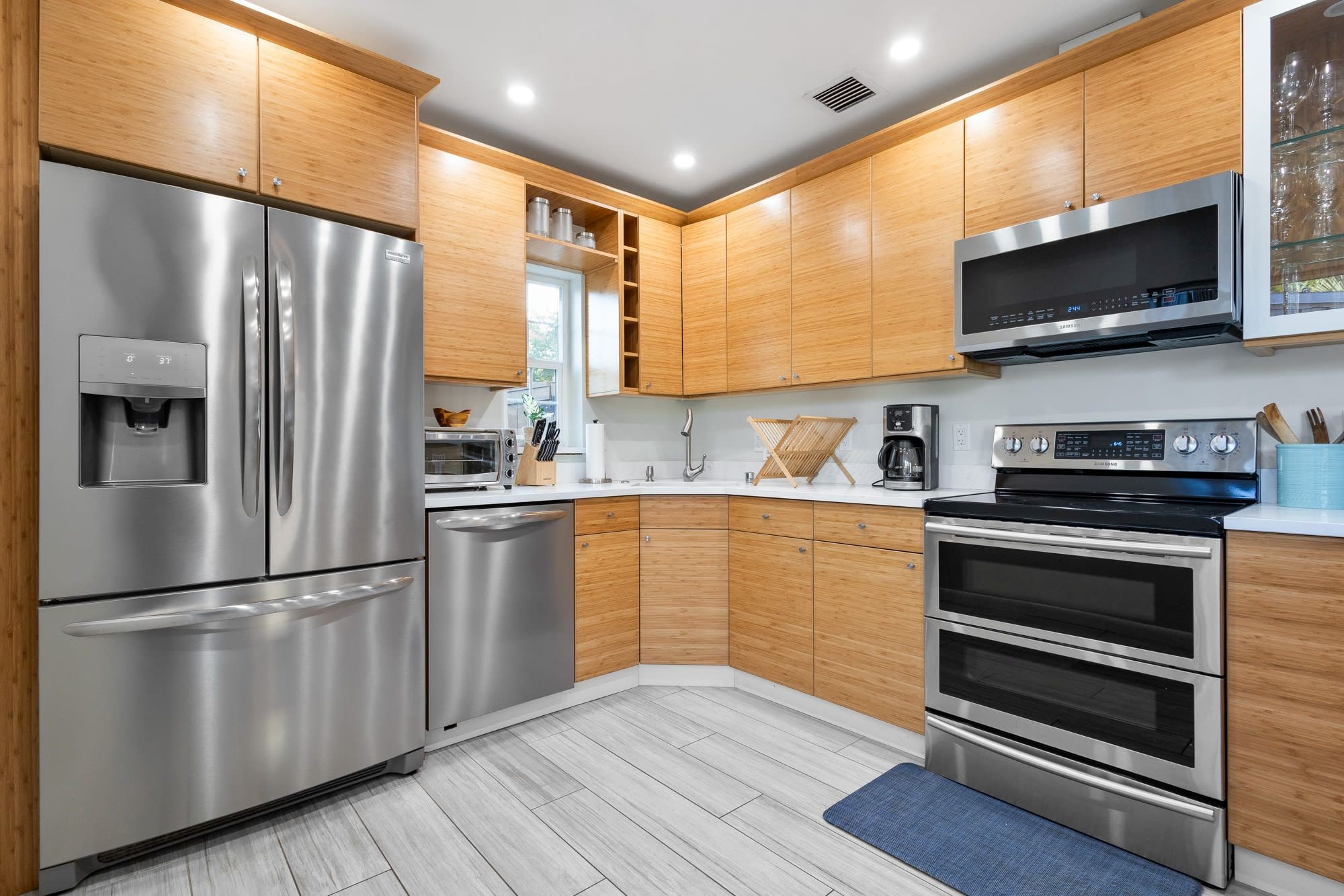 Una cocina moderna con electrodomésticos de acero inoxidable, armarios de madera y un microondas.