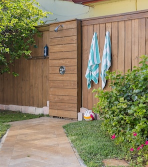 A wooden gate, a towel rack with towels, a volleyball, and a garden path.