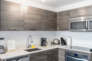 Eine moderne Küche mit integriertem Mikrowellenherd, Kaffeemaschine und Geschirrspüler.