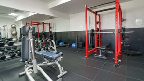 A gym with weightlifting equipment, benches, and a mirrored wall. - Brickell Bay View- Unbeatable Location With Parking (Miami)