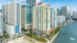 A high-rise hotel with multiple floors, a waterfront view, and a marina with boats. - Brickell Bay View- Unbeatable Location With Parking (Miami)