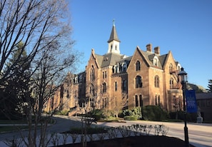 A large, historic building with a prominent tower and arched windows, surrounded by well-maintained landscaping. - Serene Stay With Amenities & Breakfast bar (West Orange)