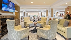 A spacious living area with a fireplace, comfortable seating, a television, and a view to the dining area. - Serene Stay With Amenities & Breakfast bar (West Orange)