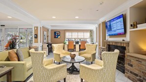 A living room with a fireplace, a TV, and a dining area with chairs and a table. - Serene Stay With Amenities & Breakfast bar (West Orange)