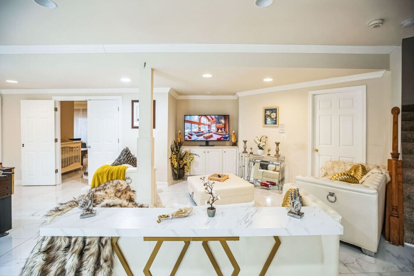 A spacious living room with a marble coffee table, a television, and a sofa.