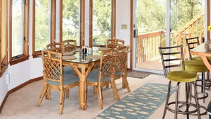 A dining area with a wooden ceiling, large windows, and a view of trees. - Walk to Beach, Jacuzzi, Treetop Deck, 4WD Pass, Love Pets! (Corolla)