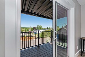 Un balcon donnant sur un parking et sur des espaces verts.
