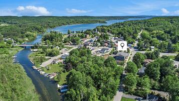 An aerial view of a lakeside community with a prominent church, a bridge, and a boat dock.