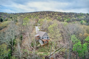 Una casa rodeada de bosque, con terraza.