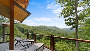 A wooden deck with lounge chairs overlooking a forested mountain range. - Sky's the Limit at Blue Ridge Mountain Club (Boone)