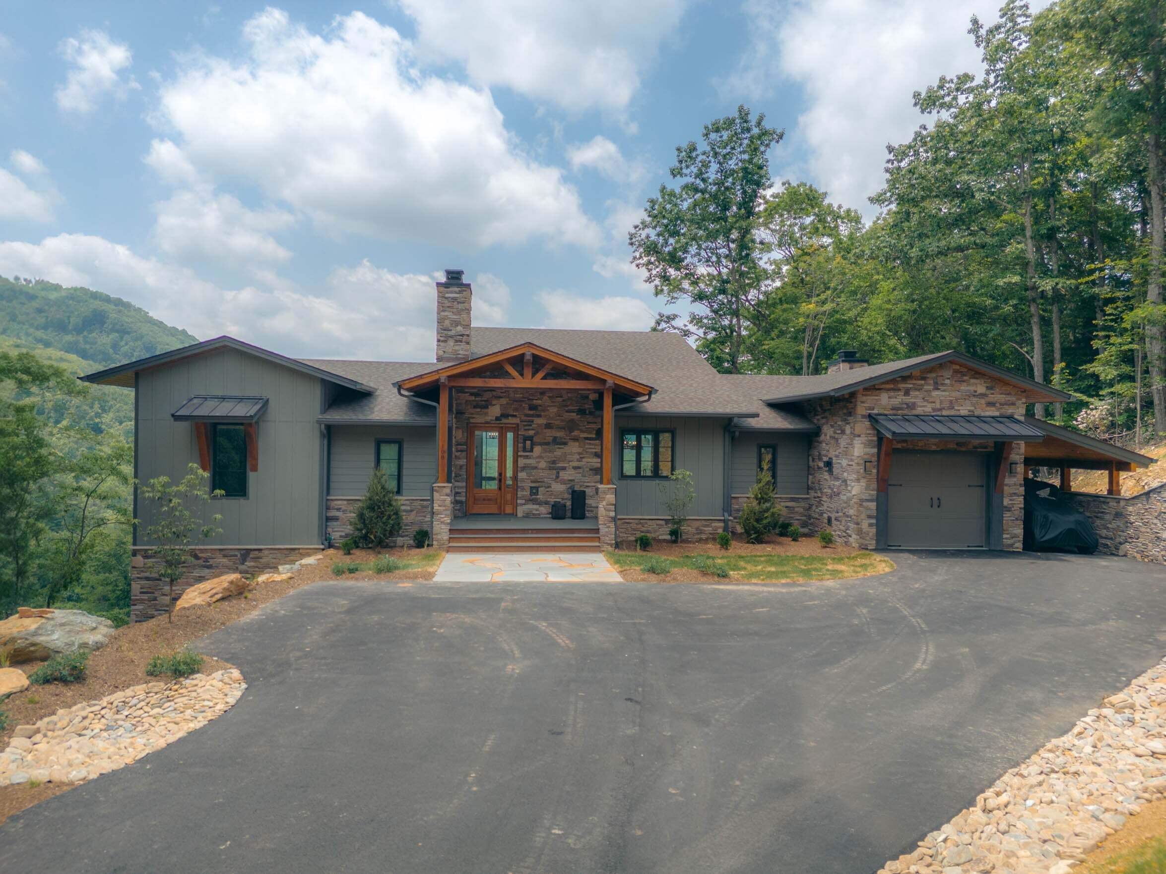 A two-story house with a stone facade, a front porch, and a garage.