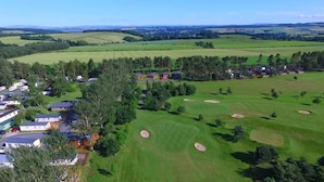 A golf course with a clubhouse, surrounded by residential buildings and trees. - Lillardsedge Apartment Sleeps 6 With Parking (Jedburgh)