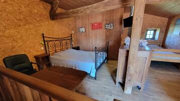 Une pièce rustique en bois, avec un lit, un bureau et une chaise.