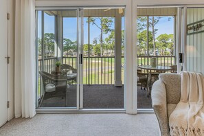 A room with a sliding glass door leading to a balcony with outdoor furniture.