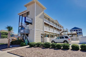 A multi-story hotel with a sign indicating it is a Tiffani's property. - Surf City Surfside Sanctuary motel (Surf City)