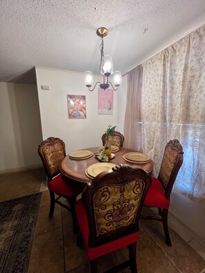 A dining area with a round table, six chairs, and a chandelier. - Condo • 2 Beds •1 ba near Downtown-Riverwalk, La cantera-Fiesta Texas, Sea World (San Antonio)