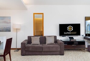 Ein modernes Wohnzimmer mit einer Couch, einem Fernseher und einem Schreibtisch.