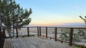 A wooden deck with a view of a mountainous landscape.