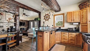 Una cocina con armarios de madera, una isla central y una decoración rústica.