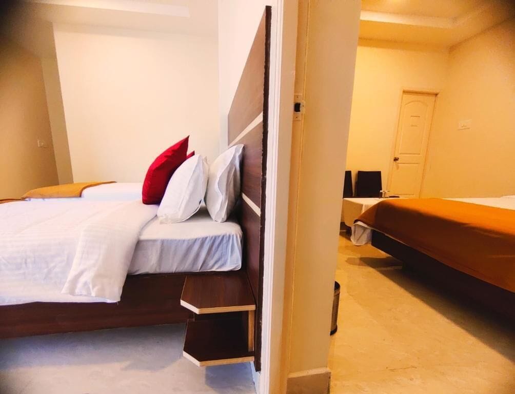 Una habitación de hotel con una cama, una mesita de noche, una silla y una puerta.