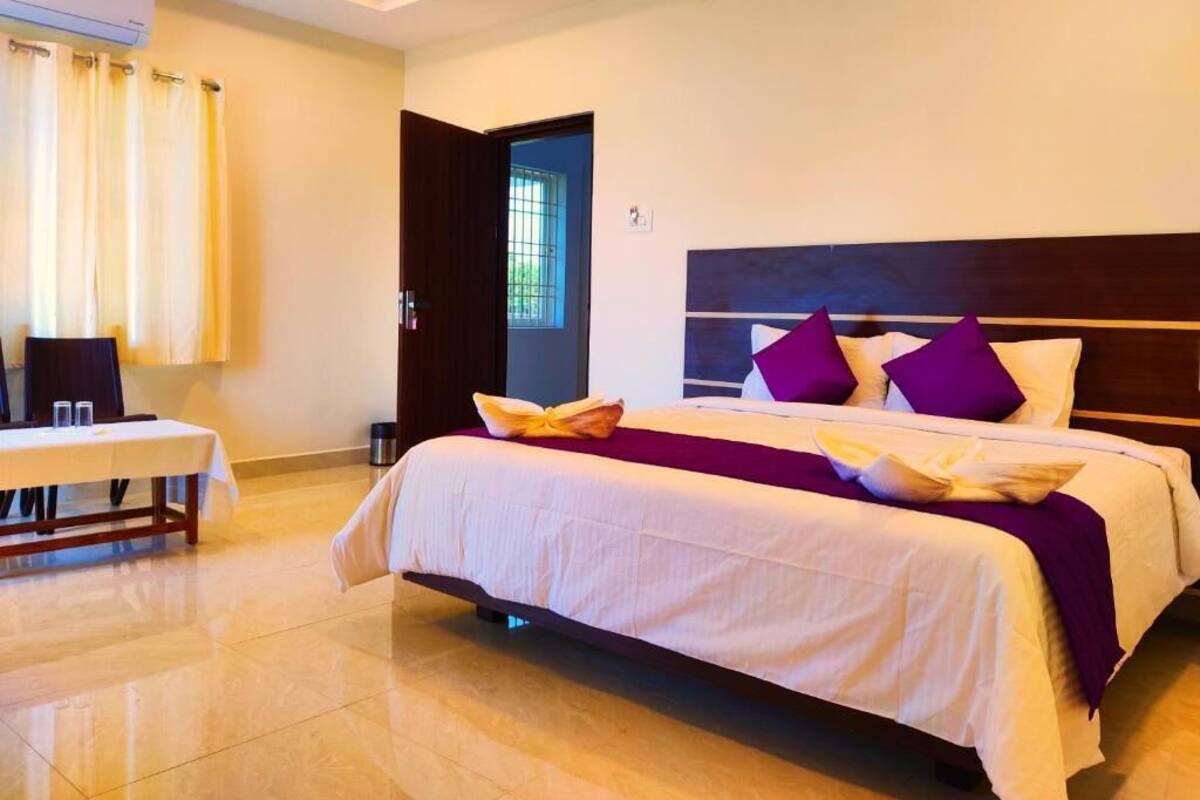Una camera d'albergo con un letto, un tavolo e una finestra.