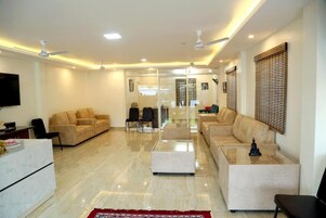Una sala de estar moderna con un conjunto de sofá, una mesa de centro y un televisor montado en la pared.